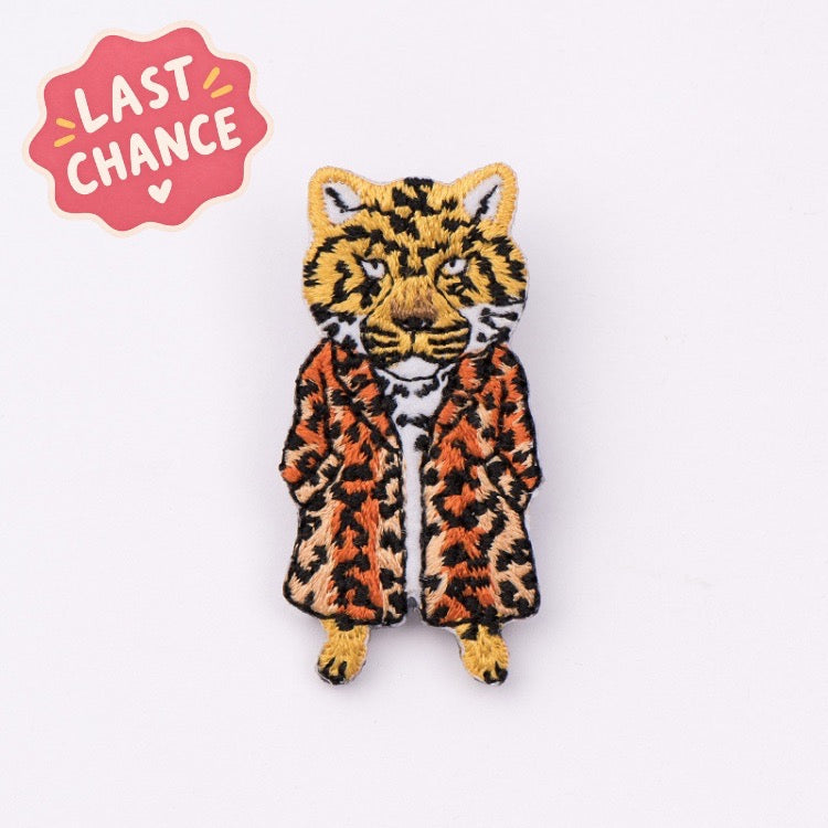 tiger in leopard fur coat embroidered stick-on patch — upright tiger with striped face and spotted coat hands in pockets