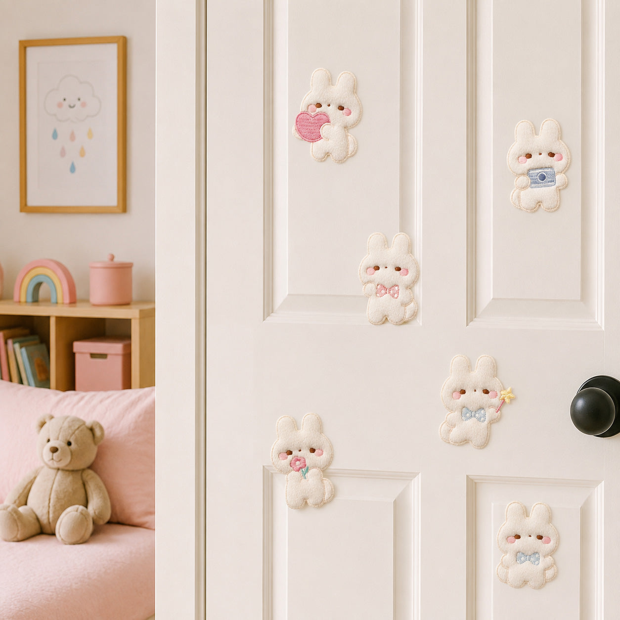 fluffy white bunny holding heart camera and flower with pink and blue bow stick-on patches displayed on a white bedroom door