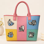 tabby cat in teacup and laptop stick-on patches decorating a pink color-block leather handbag