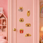 kawaii capybara face peeking from coffee cup burger baguette hot dog french fries and croissant stick-on patches on a pink closet door in a girls room