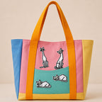 four minimalist white cat embroidered patches on a color-block canvas tote bag