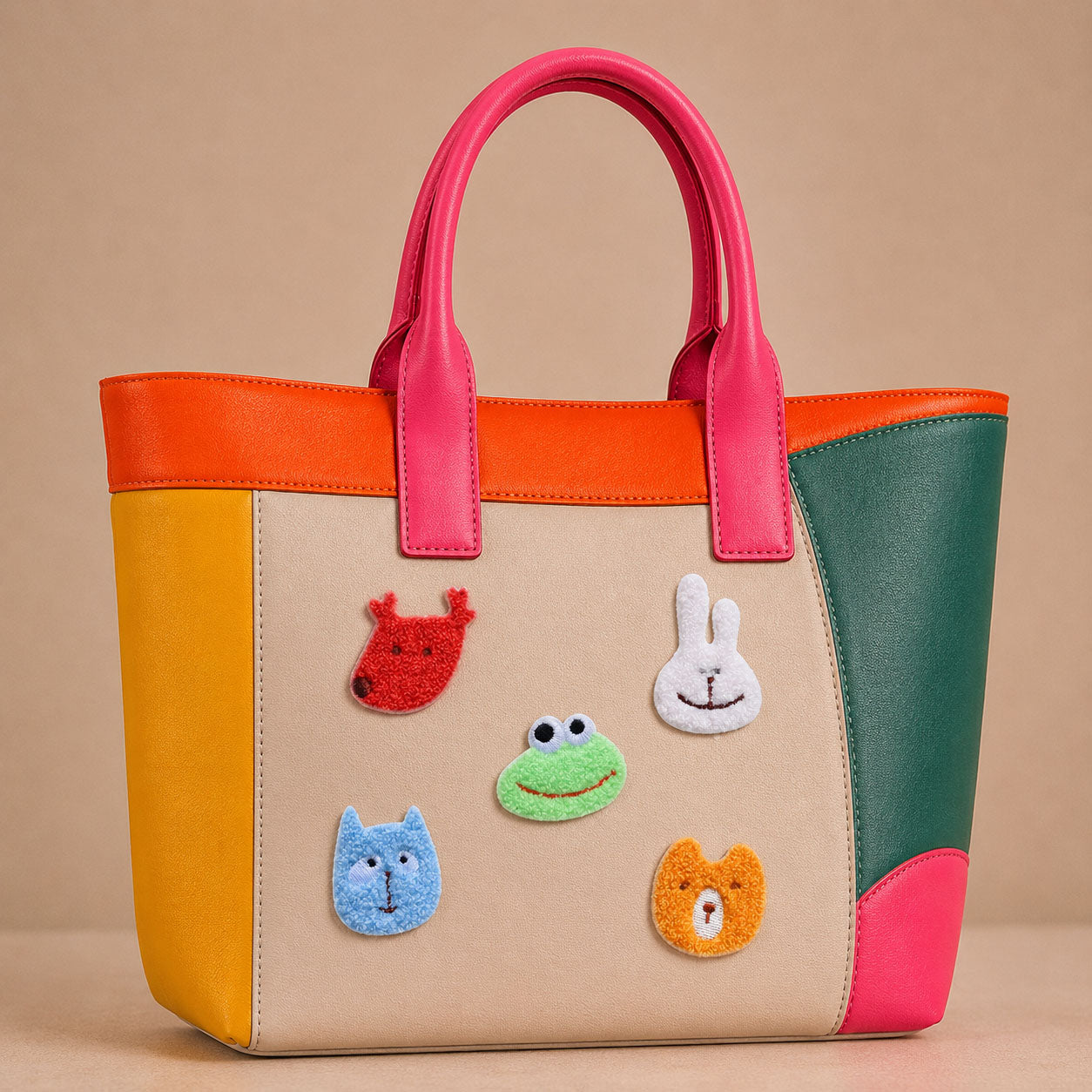 fluffy deer frog bunny cat and bear face stick-on patches decorating a pink and orange color-block leather handbag