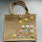 assorted botanical embroidered patches arranged as a garden on a burlap tote bag