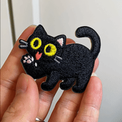 animated hand holding packaged black cat expressions embroidered patches showing ten styles and detailed embroidery texture