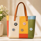 black grey pink brown and blue cat paw print stick-on patches scattered on a multicolor stripe leather handbag