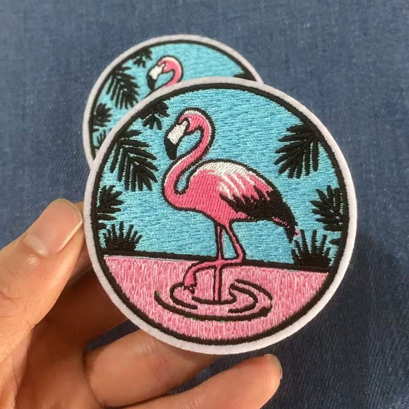 tropical flamingo embroidered stick-on patch held in hand showing round badge design