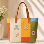 vintage ditsy floral alphabet patches A B C F on a bold orange yellow and green color-block leather tote bag