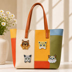 four realistic cat breed embroidered patches on a bold orange yellow and green color-block leather tote bag