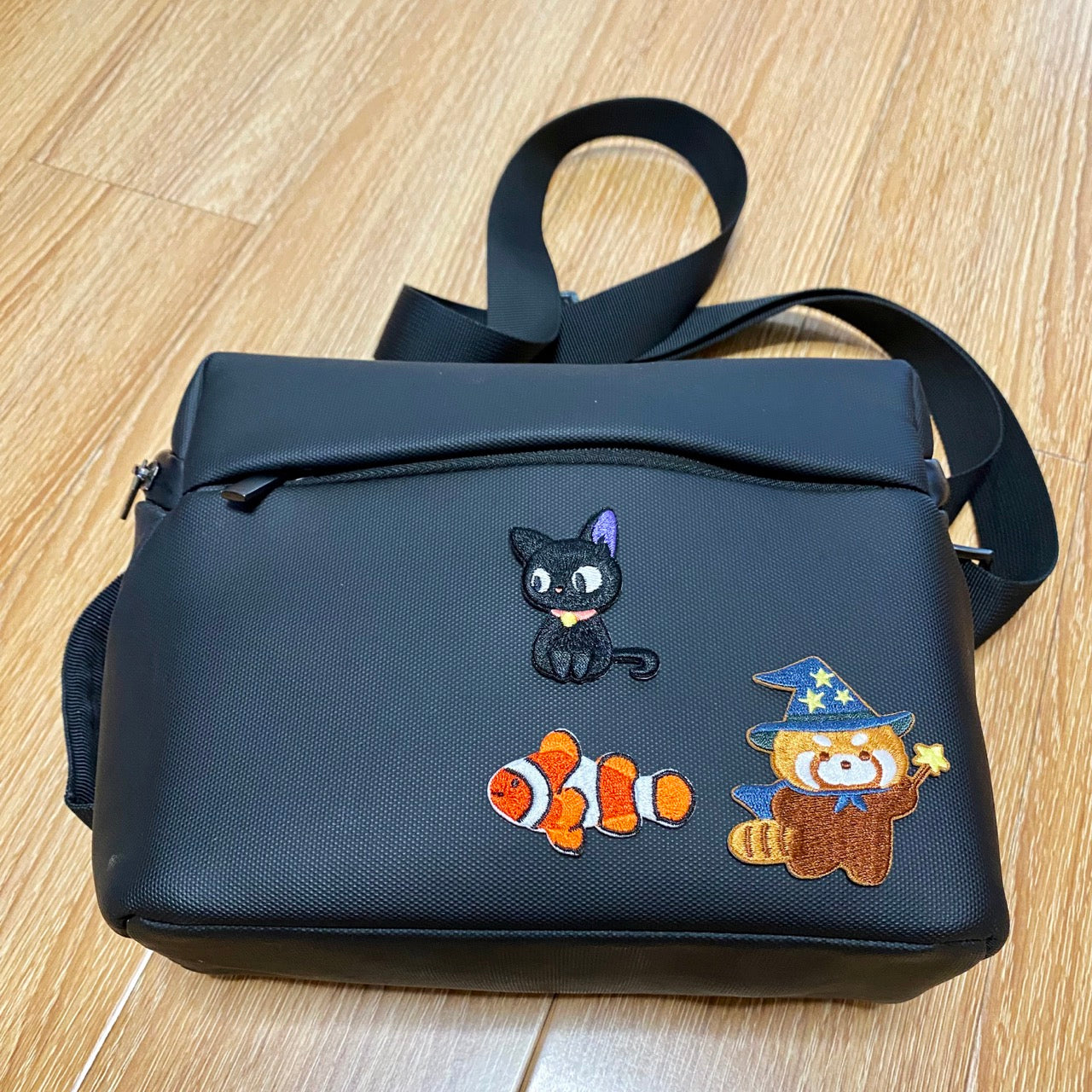 cat's diary embroidered patch on a camera bag