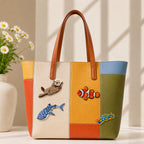 sea otter clownfish whale shark and tropical fish stick-on patches decorating a multicolor stripe leather handbag