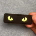 glow-in-the-dark cat eye embroidered stick-on patches held in hand