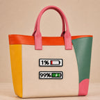 two battery status embroidered patches showing 1% and 99% on a bold color-block leather tote bag