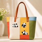 fluffy black and white panda rolling tumbling and kicking stick-on patches decorating a multicolor leather handbag