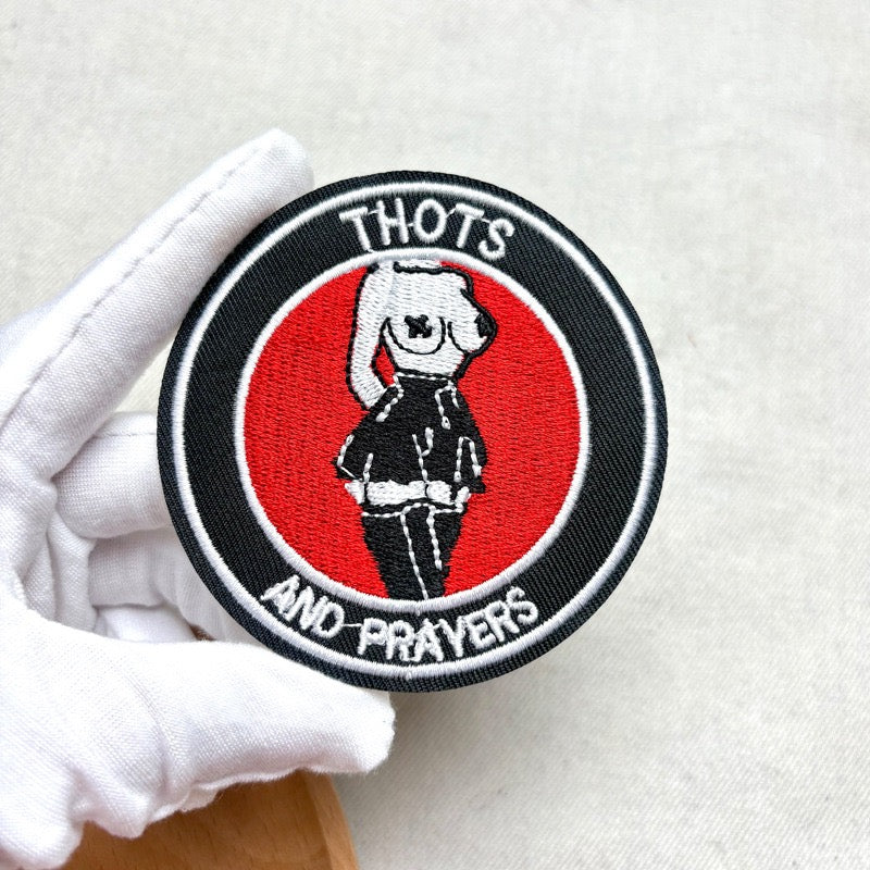 thots and prayers embroidered stick-on patch held in hand showing round badge design