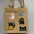curious explorer void cat embroidered stick-on patch on a jute tote bag
