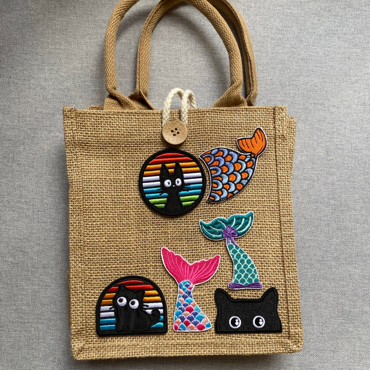 black cat in rainbow window embroidered stick-on patch on a jute tote bag