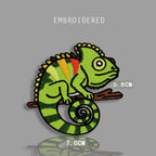 colorful chameleon lizard embroidered stick-on patch — vivid green chameleon on branch with yellow orange red back panels yellow dorsal spines spiral tail round eye 70x68mm