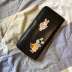 Black zippered case displaying ballerina bunny and winter bunny embroidered patches
