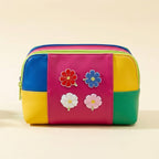 red blue white and pink cosmos flower stick-on patches decorating a colorful color-block leather pouch