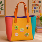 retro cactus mushroom character and daisy stick-on patches decorating an orange and yellow color-block leather handbag