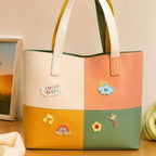 cute summer embroidered patches with cute day cloud sun rainbow music notes and flower on a colorblock tote bag in cream pink yellow and green