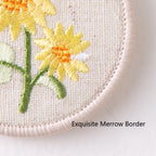 close-up embroidery detail of botanical floral double-sided keychain charm