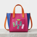 retro flower stamp embroidered patches scattered on the front pocket of a hot pink color-block leather bag