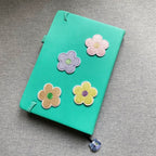pastel macaron flower embroidered stick-on patch on a notebook