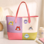 penguin in shark crab and jellyfish costume stick-on patches decorating a purple and white color-block leather handbag