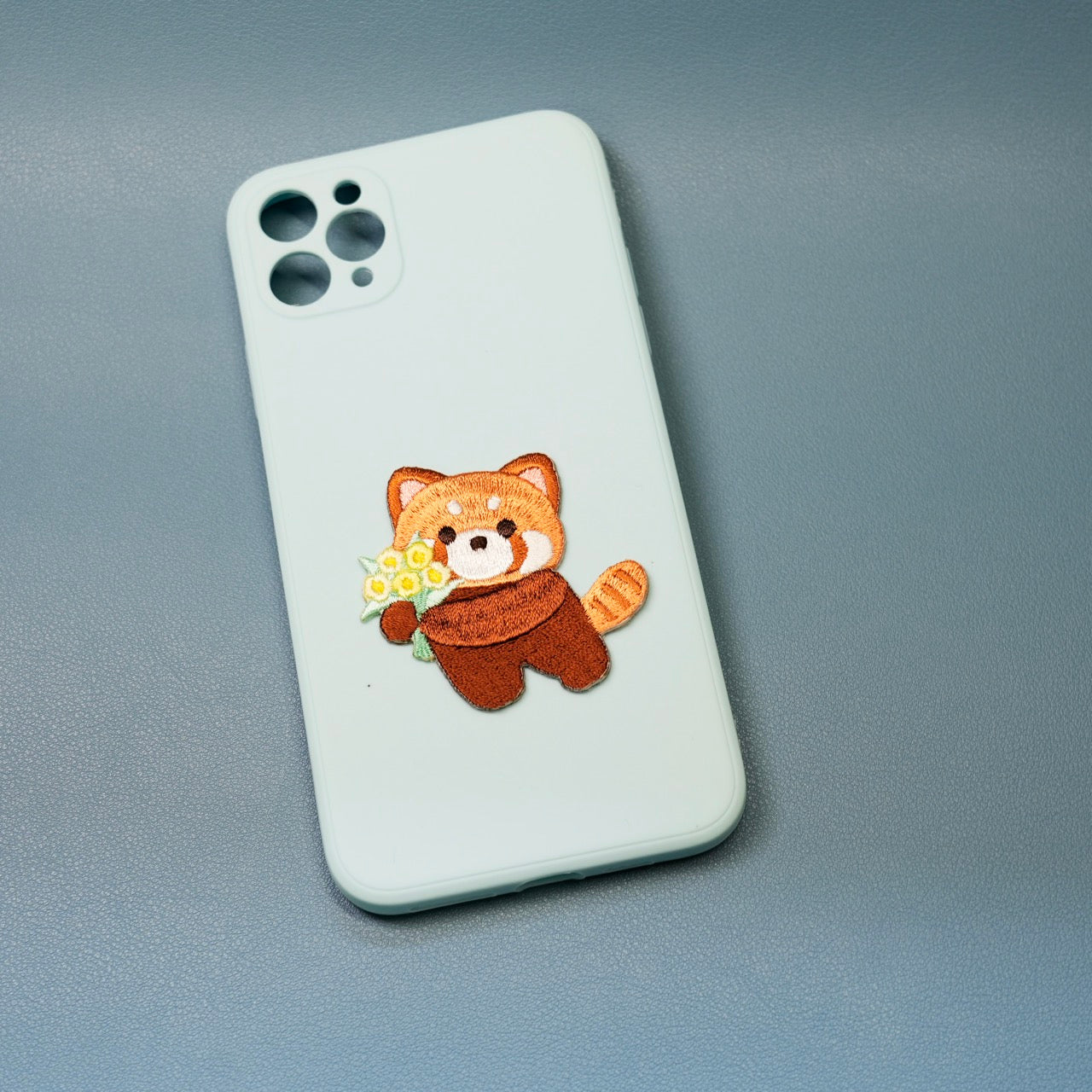 red panda embroidered patch sticker on a phone case