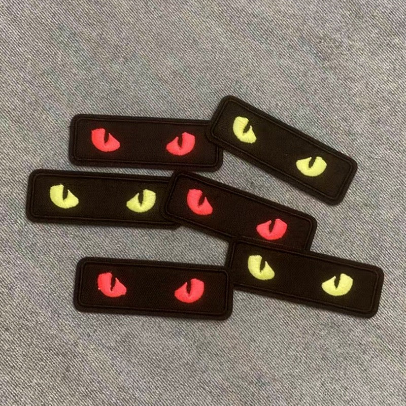 glow-in-the-dark cat eye embroidered stick-on patches flat lay on table