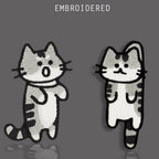 Two funny gray tabby cat embroidered stick-on patches with contrasting expressions
