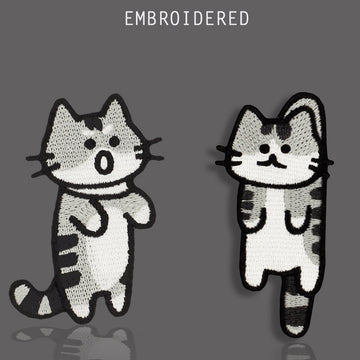 Two funny gray tabby cat embroidered stick-on patches with contrasting expressions
