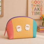 cute chubby alpaca stick-on patches decorating a pastel color-block leather makeup bag
