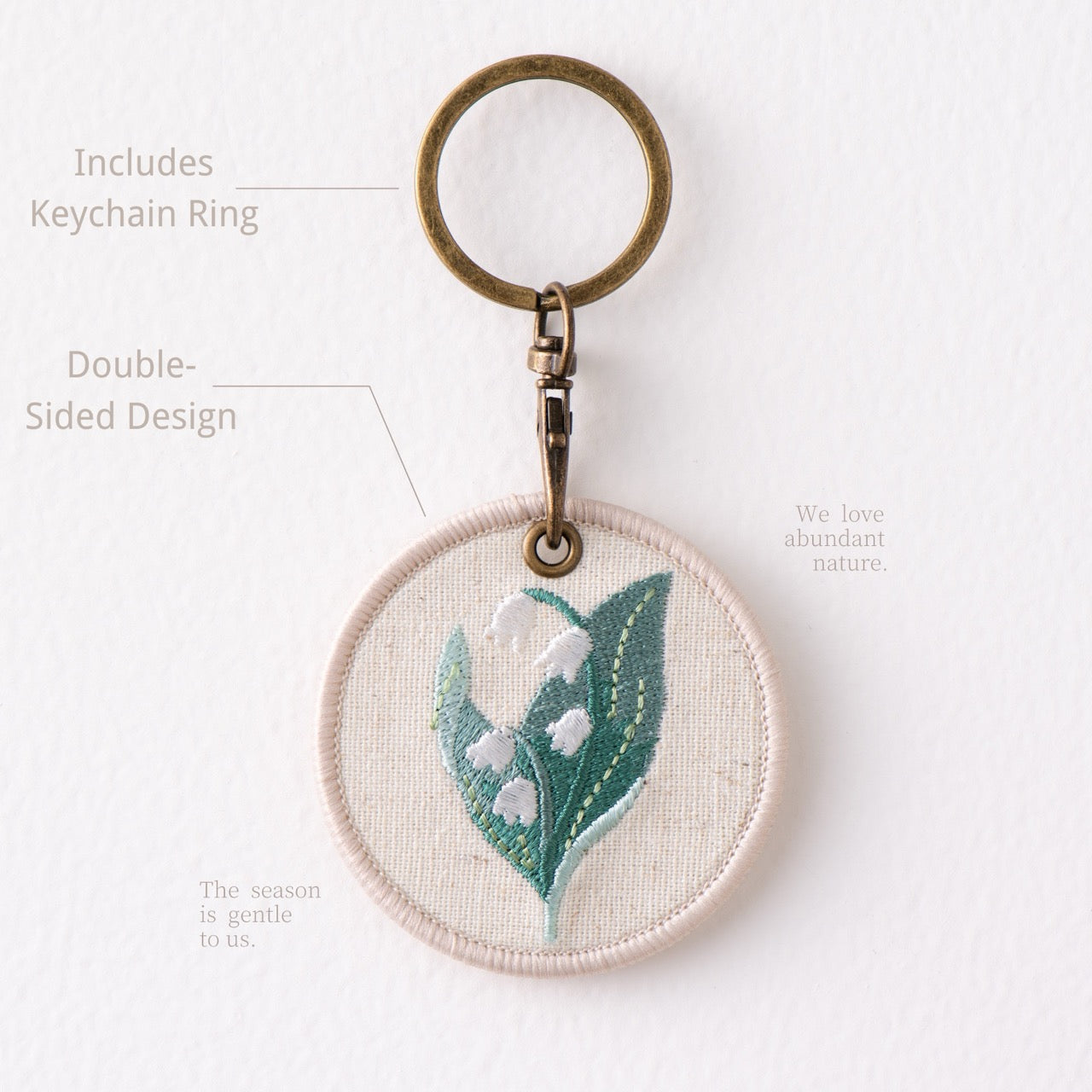 full view of botanical floral double-sided embroidered keychain charm with antique bronze hardware