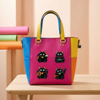 lucky beckoning black cat embroidered stick-on patches on a colorful color-block leather tote bag