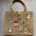 chubby cat embroidered stick-on patches in various poses on a natural jute tote bag