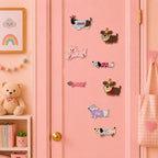 long dachshund in dog sweater with crown party hat pink bow bone shape polka dot purple s sweater and plaid stick-on patches scattered on a pink door in a pastel room