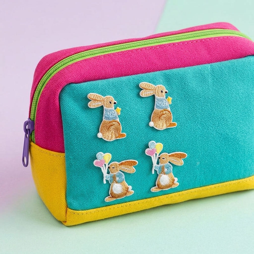 cute bunny with balloons stick-on patches decorating a pink and teal canvas zip pouch