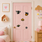 black cat with bat wings sitting on jack-o-lantern flying bat cat and spider web halloween stick-on patches on a pink bedroom door