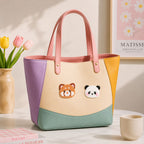 red panda and giant panda embroidered patches on a pastel color-block leather tote bag