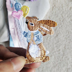holding a bunny balloon embroidered stick-on patch in hand