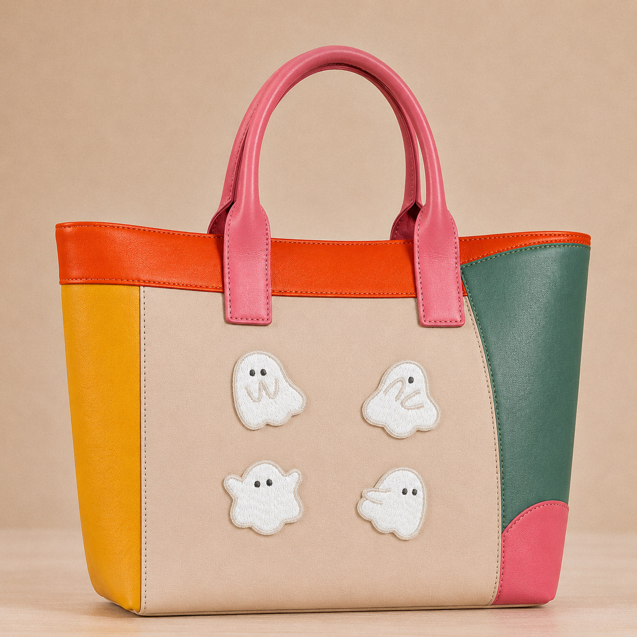 fluffy white ghost in various poses stick-on patches decorating a pink and orange color-block leather handbag