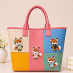 cute fox in Chinese traditional dress stick-on patches decorating a pink and blue color-block leather handbag