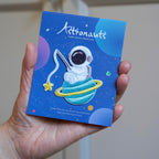 holding a kawaii astronaut embroidered stick-on patch in hand
