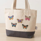 colorful monarch butterfly embroidered stick-on patch on a canvas tote bag