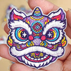 Chinese guardian lion dance embroidered stick-on patches — four colorways including red gold purple yellow pink floral and blue purple lion dance heads with dense layered embroidery