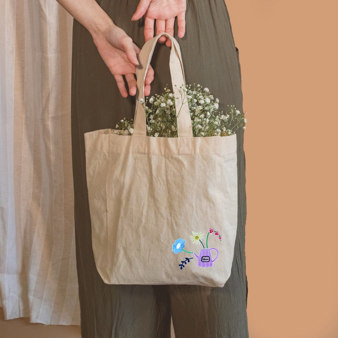 whimsical flora and ceramic vase embroidered stick-on patches on an eco tote bag