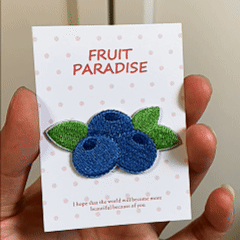animated hand holding packaged juicy fruit embroidered patches showing six styles and detailed embroidery texture
