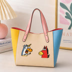 funny meme horse and unicorn embroidered patches on a cream color-block leather tote bag
